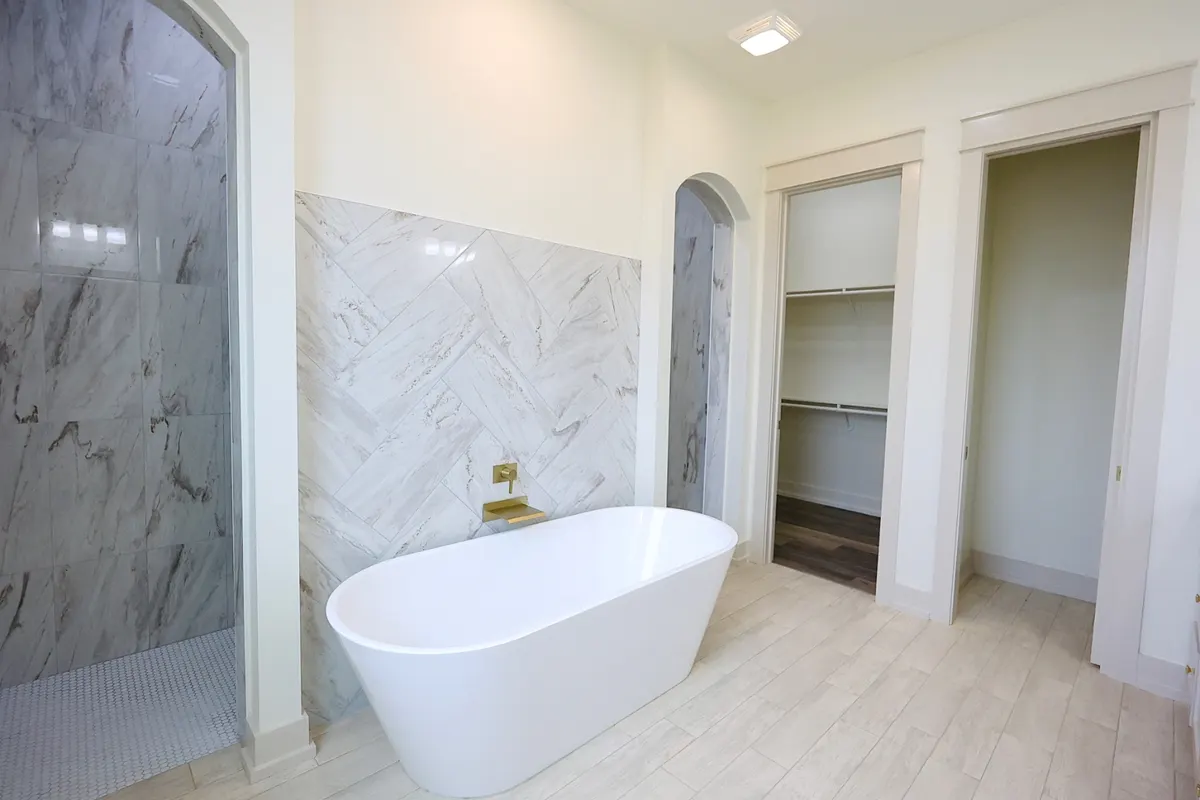 Owner's bath with freestanding tub and marble walk-in shower