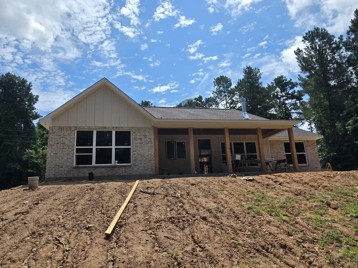 Cutze custom home under construction with brick and board-and-batten exterior