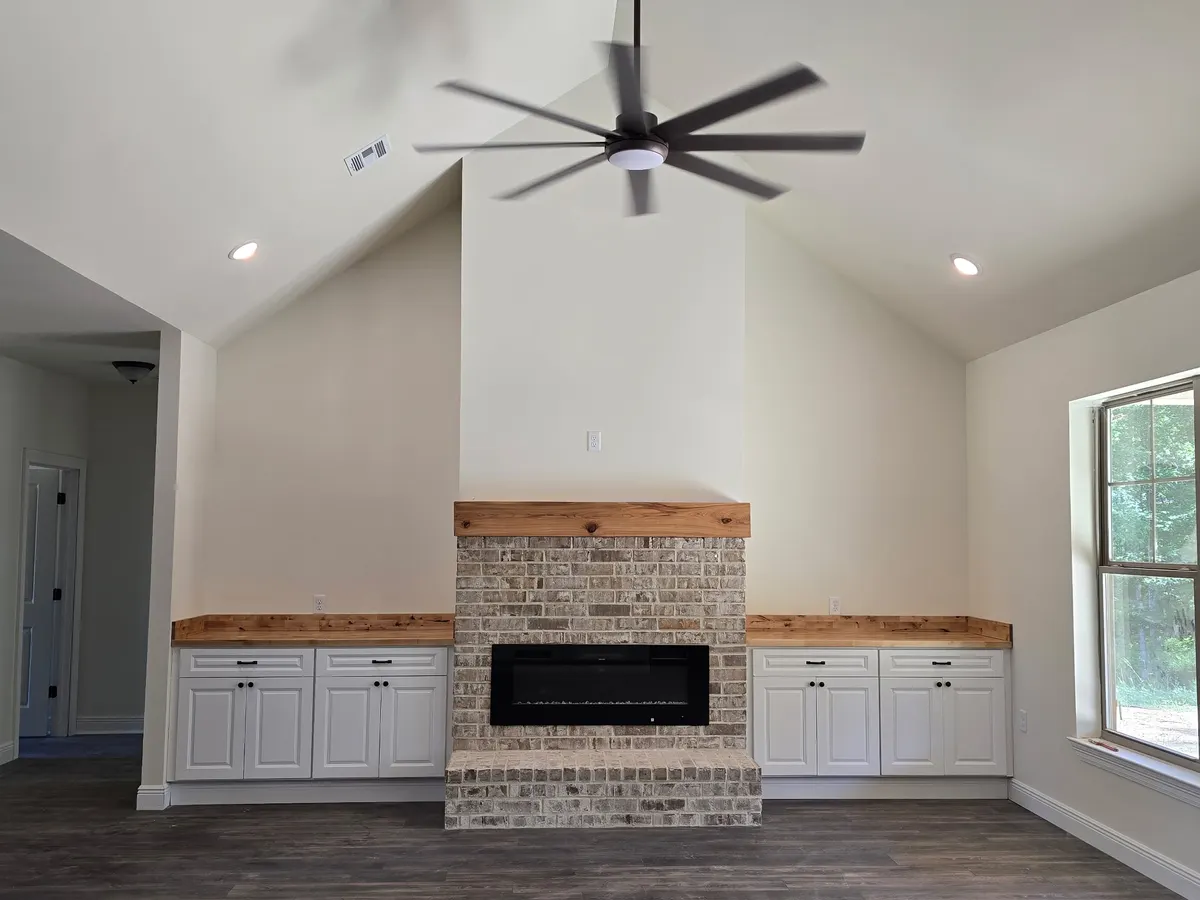 Vaulted great room with brick fireplace and wood mantel in a Cutze-built home