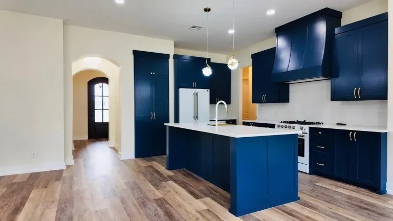 Navy custom kitchen with brass hardware and quartz island