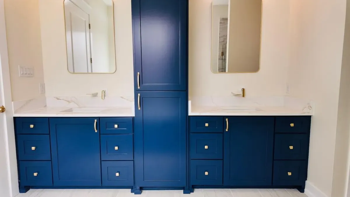 Navy double vanity with marble counters and brass fixtures in a Cutze-built home